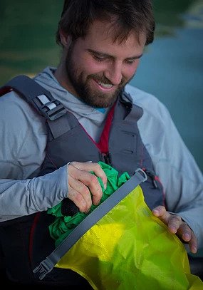 A man pulls a jacket out of a waterproof bag