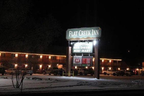 A photo of the Flat Creek Inn sign at night in Jackson Hole