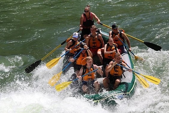 A group in a raft rides a rapid during a Jackson Hole Whitewater rafting trip