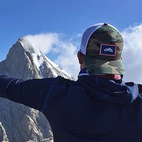 A man in a backwards hat stares out at the Grand Tetons in Jackson Hole