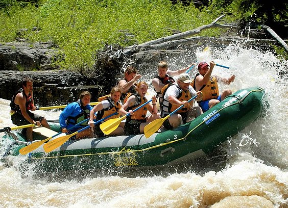 A group in a raft rides a rapid during a Jackson Hole Whitewater rafting trip