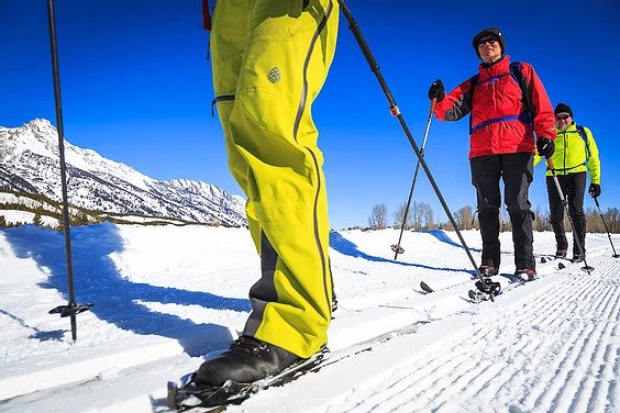 3 people cross-country ski along the Grand Tetons in Jackson Hole