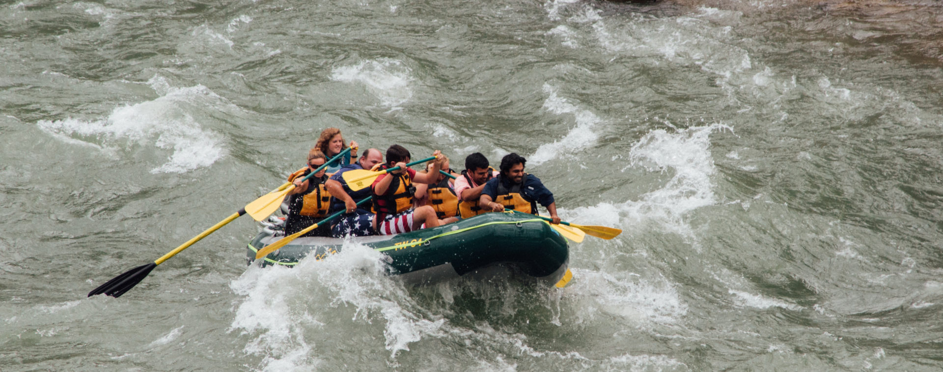A group in a raft rides a rapid during a Jackson Hole Whitewater rafting trip