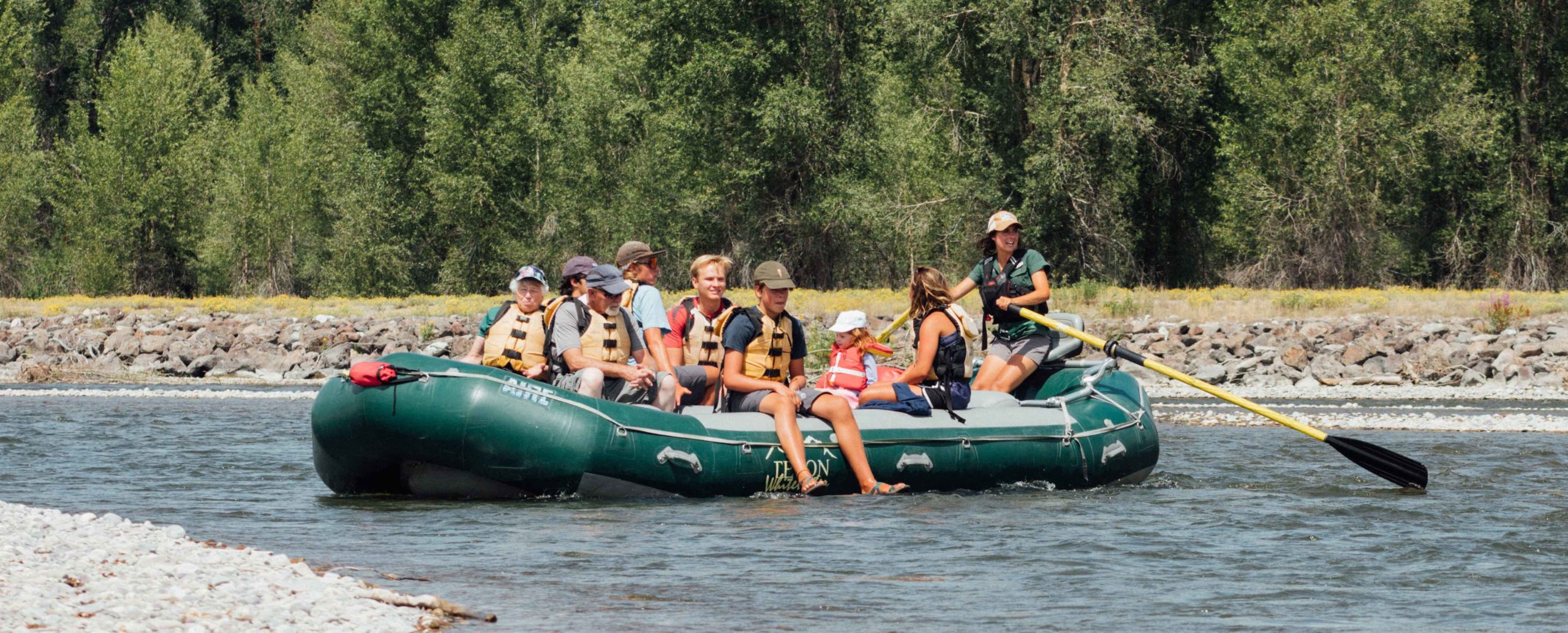A raft guide floats down the Snake River with 8 passengers