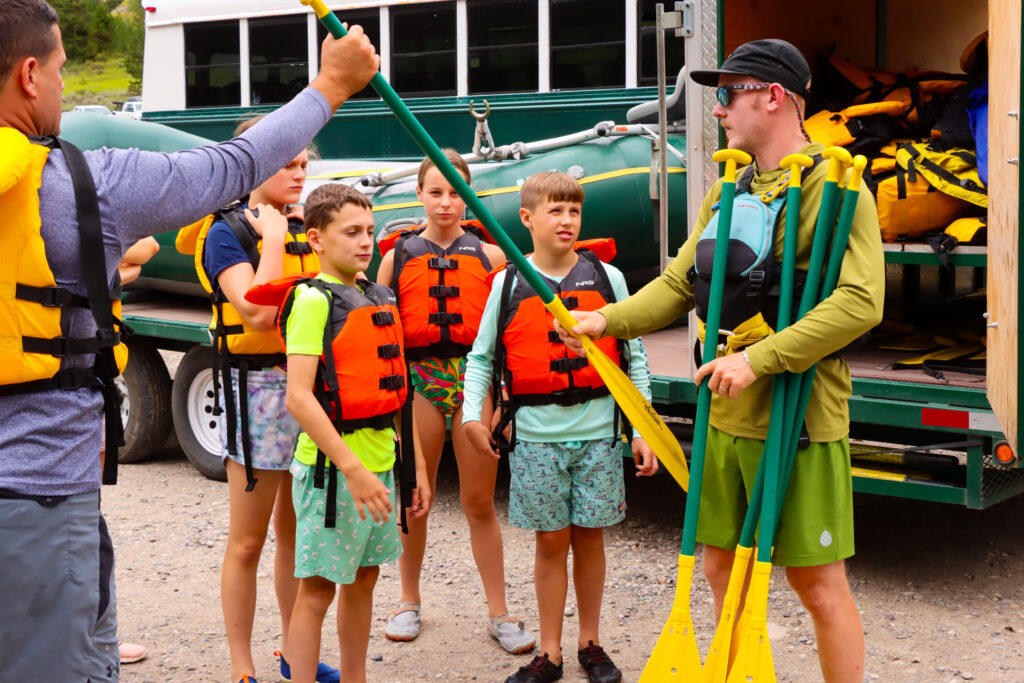 handing out paddles for whitewater rafting