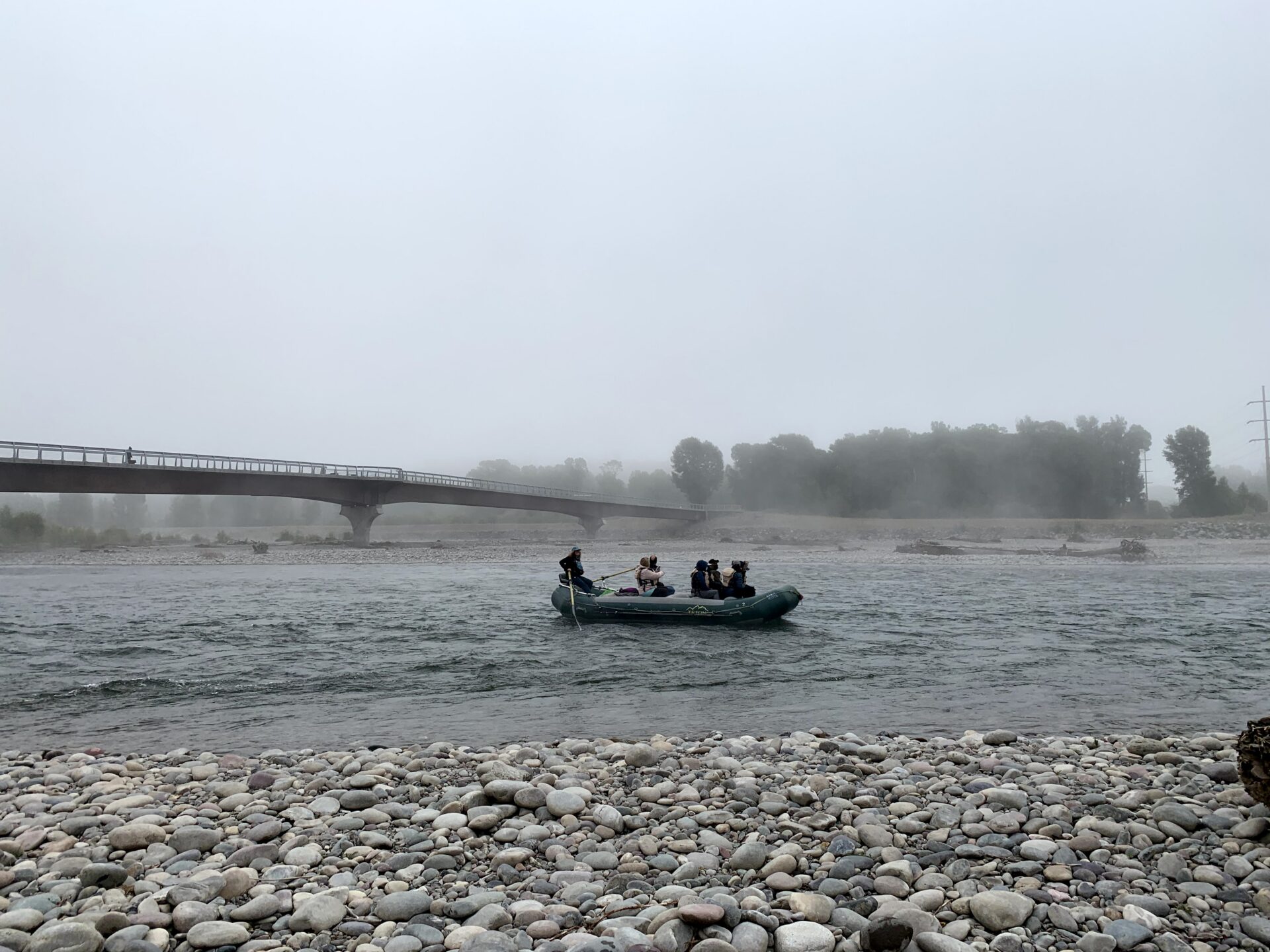 boat traveling down the snake river in the rain
